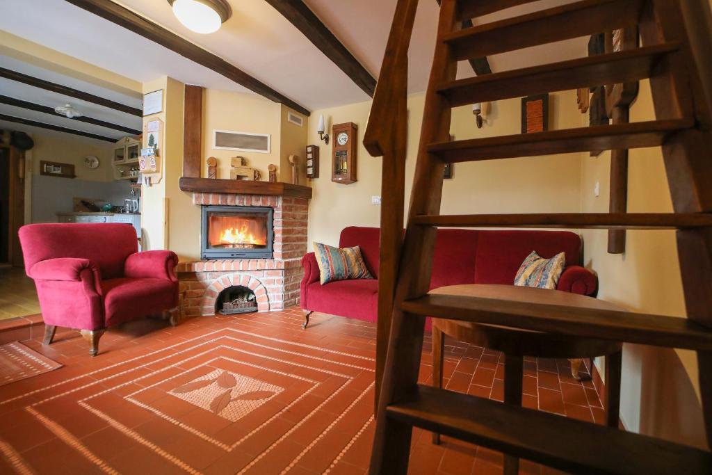 a living room with red chairs and a fireplace at Country house with a pool in Medvednica Nature Park in Zagreb