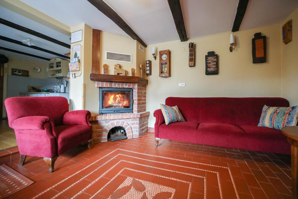 a living room with two red couches and a fireplace at Country house with a pool in Medvednica Nature Park in Zagreb