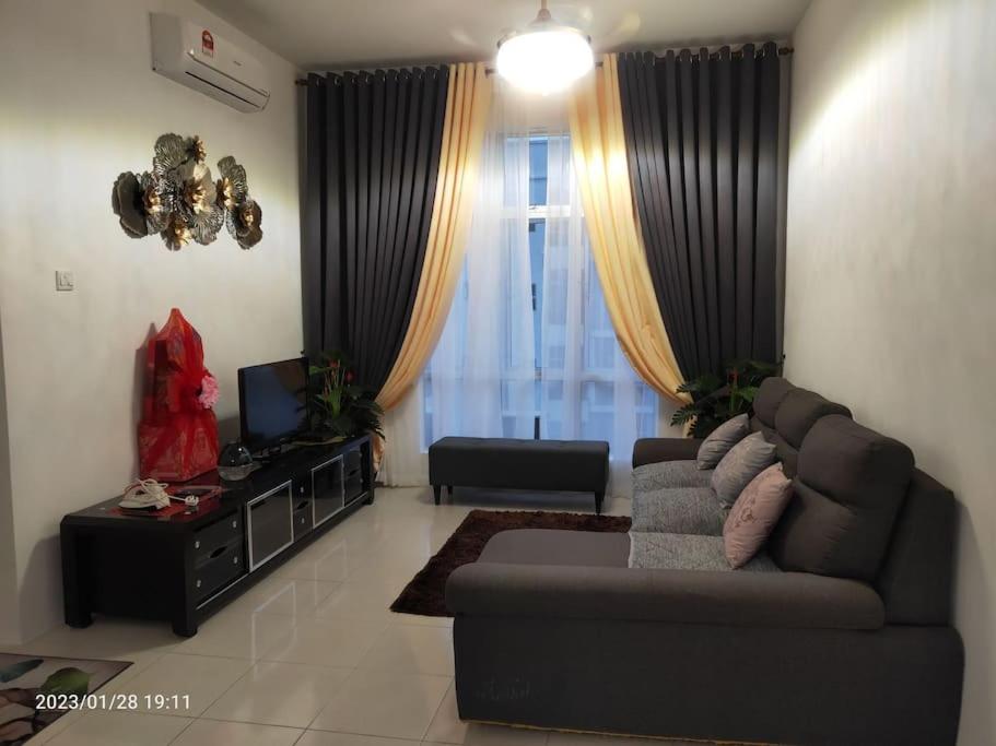 a living room with a couch and a television at Casa Klebang Homestay in Ipoh
