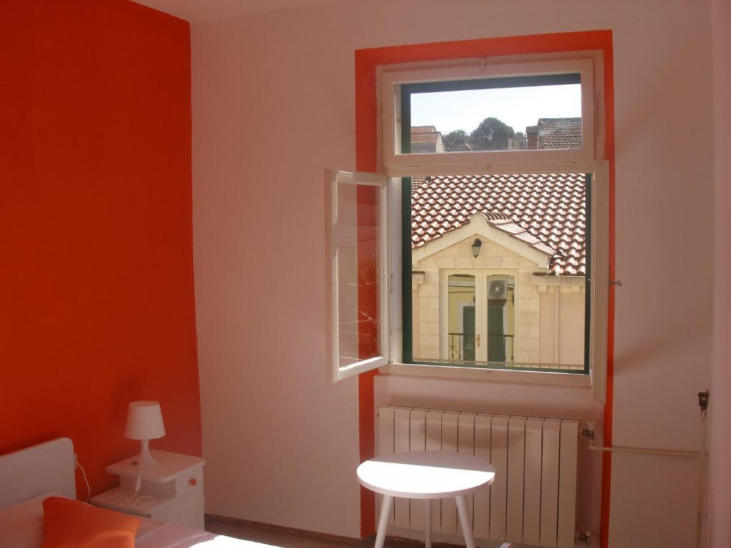 ein kleines Fenster in einem Zimmer mit einem weißen Stuhl in der Unterkunft Guesthouse Franko in Vela Luka