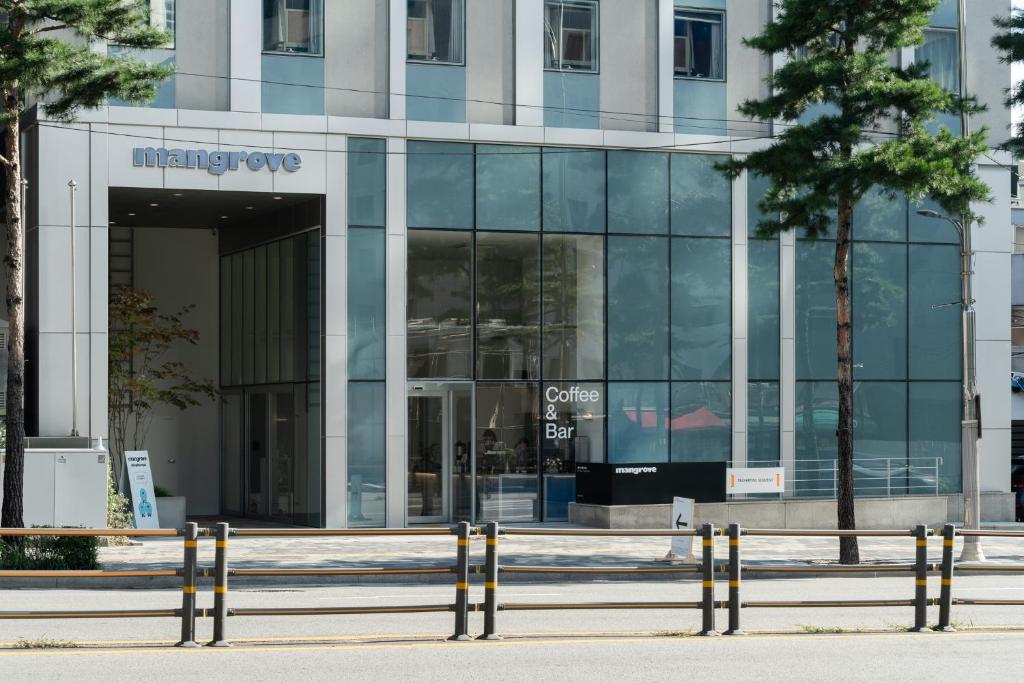 un edificio de cristal con un cartel en el costado en Mangrove Dongdaemun, en Seúl