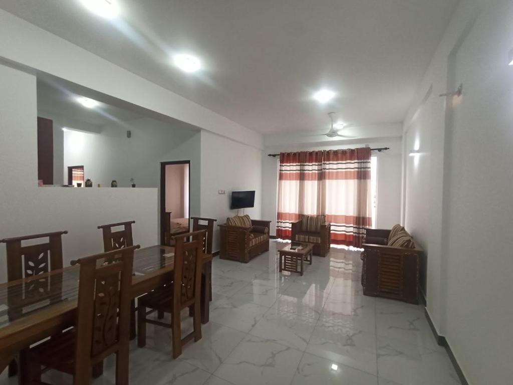 a living room with a dining room table and chairs at 3 bedroom fully furnished apartment - Vel residencies in Colombo
