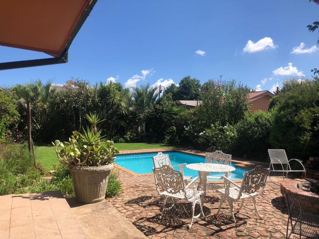a patio with a table and chairs next to a pool at Schilbach House in Parys
