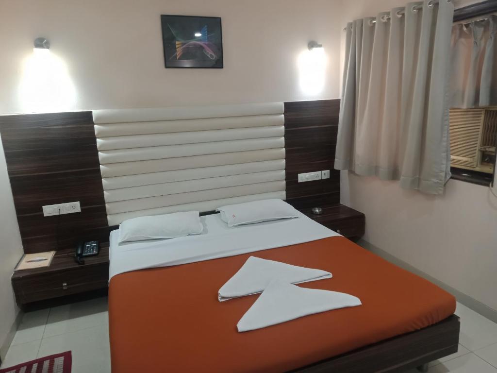 een slaapkamer met een bed met 2 kussens erop bij VALA JANU HOTELS PVT LTD in Mumbai
