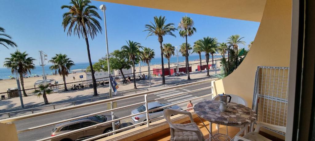 balcón con vistas a la playa y a las palmeras en Miramar Serveis - Puerto 1ª línea, en Cambrils