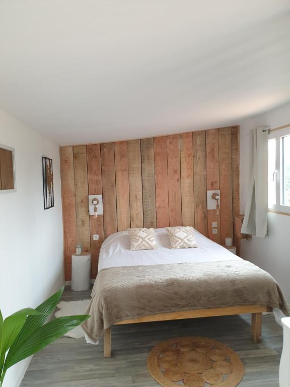 - une chambre avec un lit et un mur en bois dans l'établissement La cabane du Mas gnolia, à Saint-Jean-du-Gard