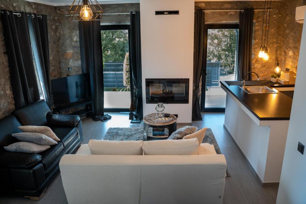 Triantos Guesthome Studio في تريبوليس: غرفة معيشة مع أريكة بيضاء ومطبخ