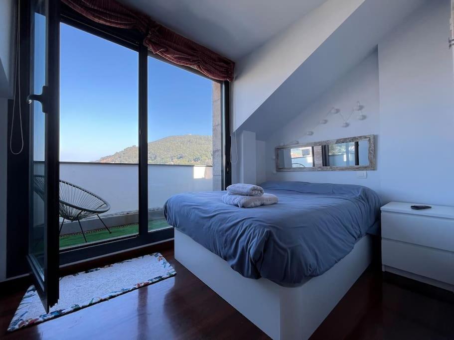 1 dormitorio con cama y ventana grande en Duplex Bahía de Santoña en Santoña