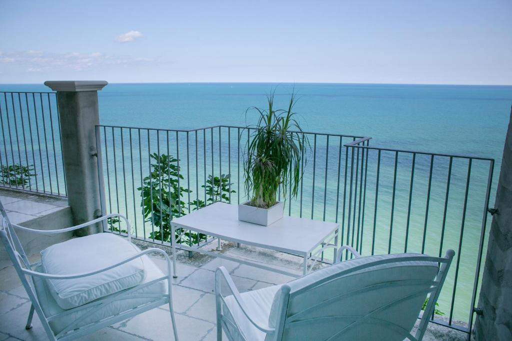 stół i krzesła na balkonie z widokiem na ocean w obiekcie dimore di portadibasso w mieście Peschici