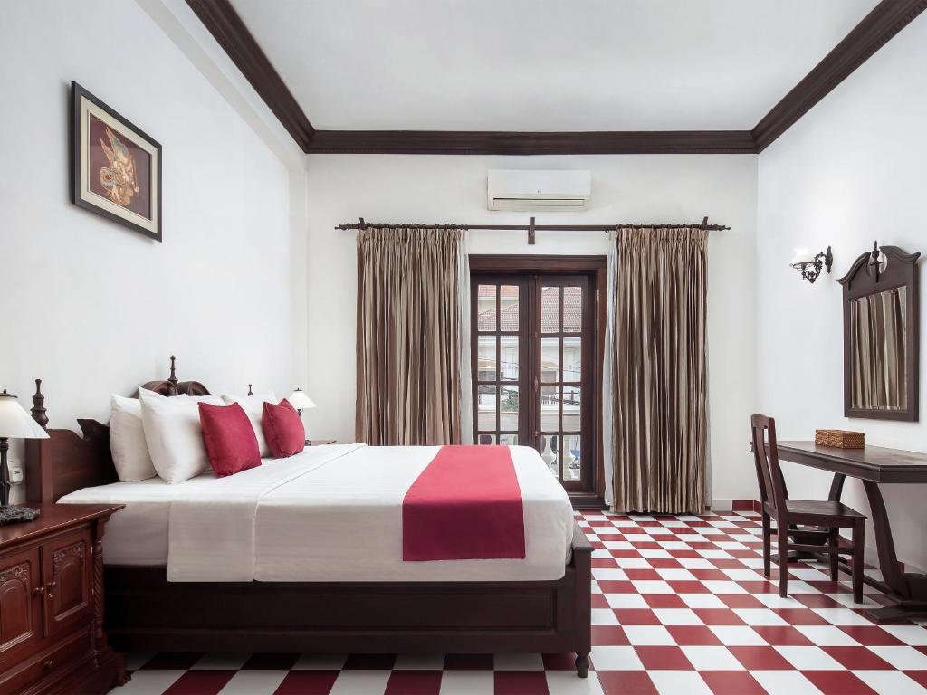 a hotel room with a bed and a desk and a table at Chateau d'Angkor La Residence in Siem Reap