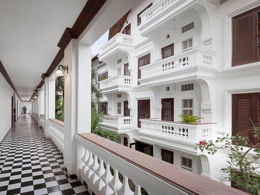 a corridor of a white building with a checkered floor at Chateau d'Angkor La Residence in Siem Reap