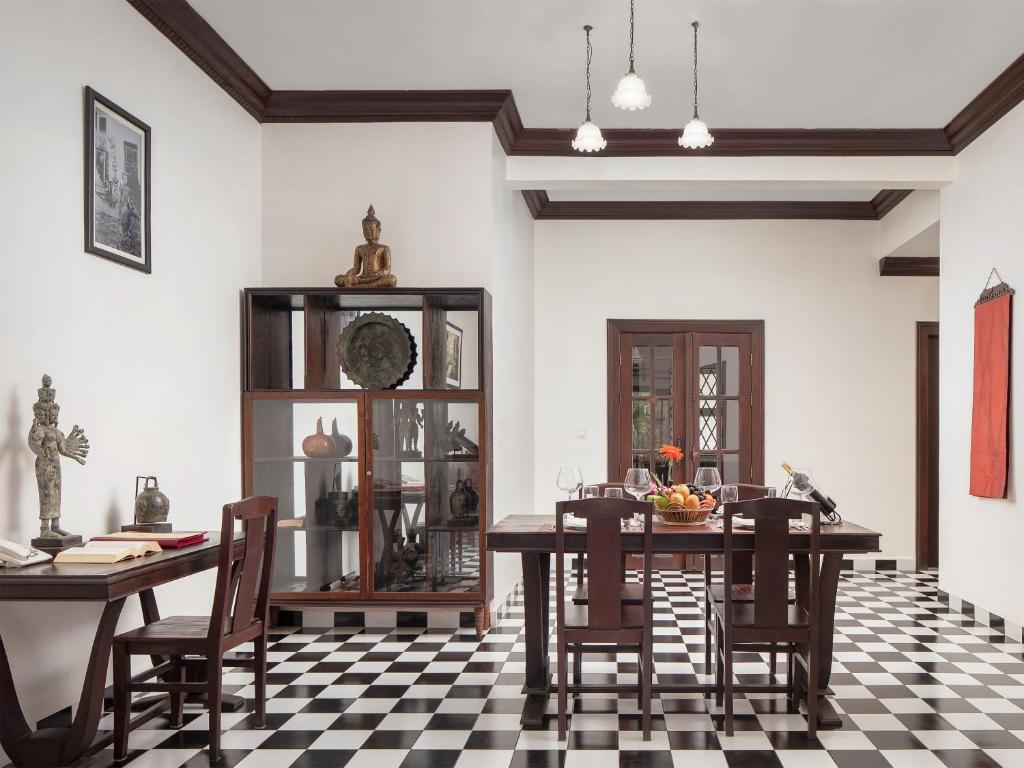 a dining room with a table and chairs on a checkered floor at Chateau d'Angkor La Residence in Siem Reap