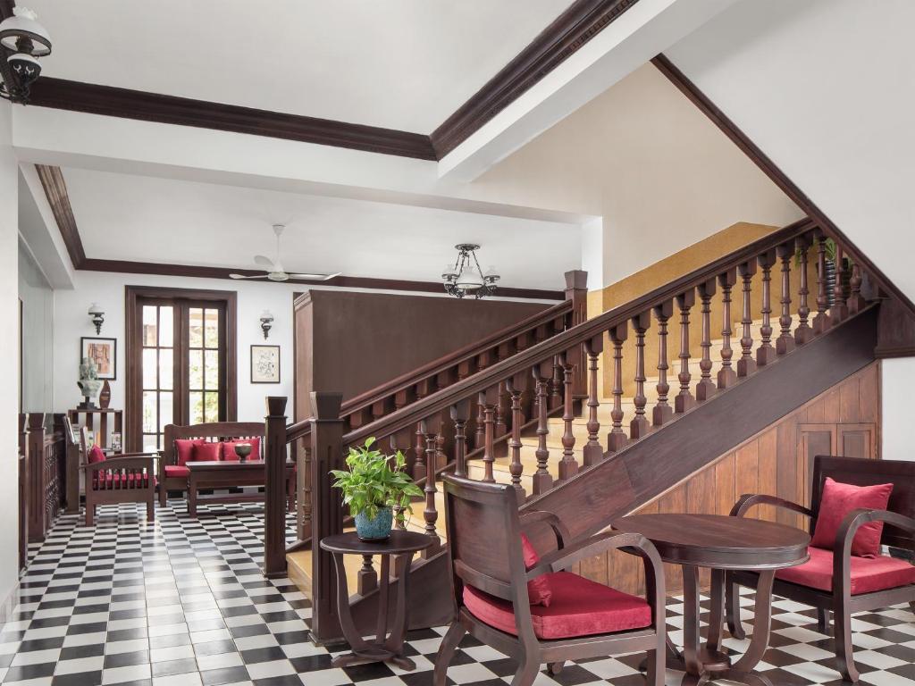 a lobby with stairs and chairs and a table at Chateau d'Angkor La Residence in Siem Reap