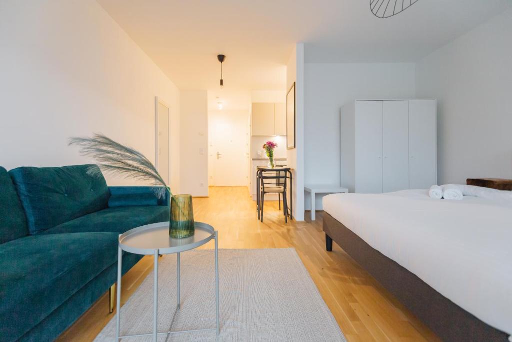 a bedroom with a bed and a couch and a table at Modern Apartment with free garage in Vienna