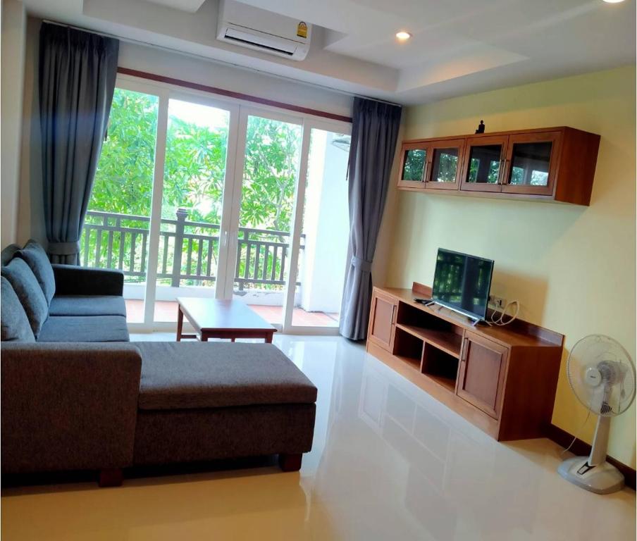 ein Wohnzimmer mit einem Sofa und einem TV in der Unterkunft Khanom Beach Residence Condo - Spacious 1-bedroom in Khanom