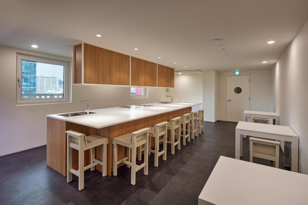 a kitchen with a large island with stools at Mangrove Sinseol in Seoul