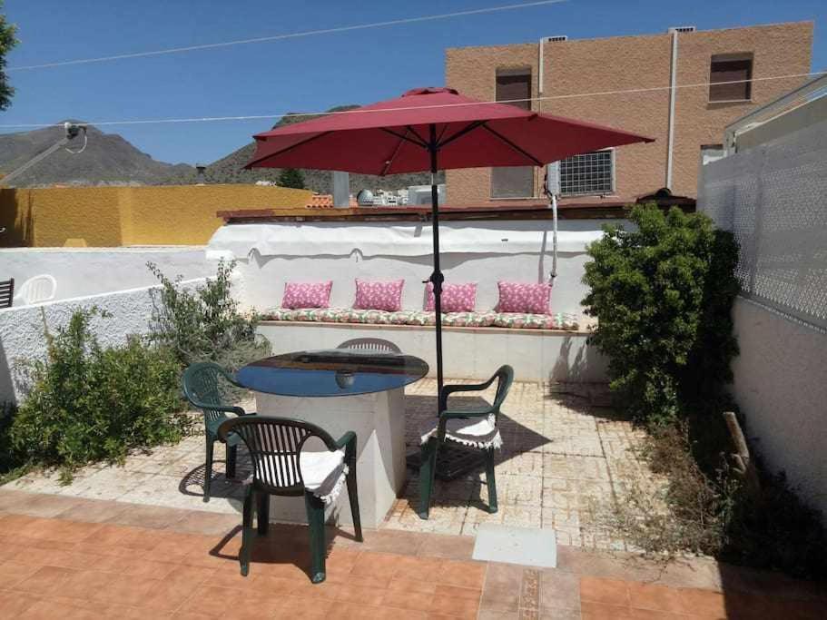 a patio with a table and chairs and an umbrella at San José Apartamento in San José
