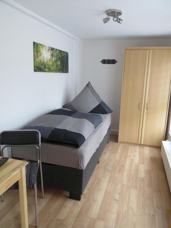 um quarto com uma cama, uma mesa e um armário em Monteurzimmer em Dresden