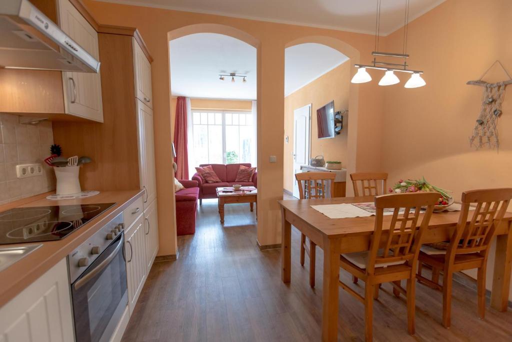 eine Küche und ein Wohnzimmer mit einem Tisch und Stühlen in der Unterkunft Villa Senta Apartment 2 in Kühlungsborn