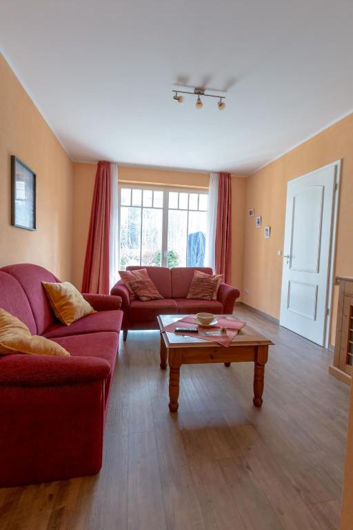 a living room with two red couches and a coffee table at Villa-Senta-Apartment-2 in Kühlungsborn