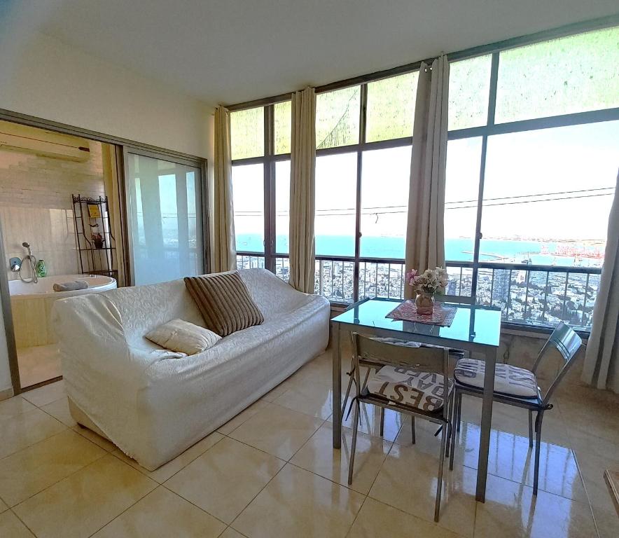 uma sala de estar com um sofá branco e uma mesa em Amazing Panorama Bay view 3 room flat em Haifa