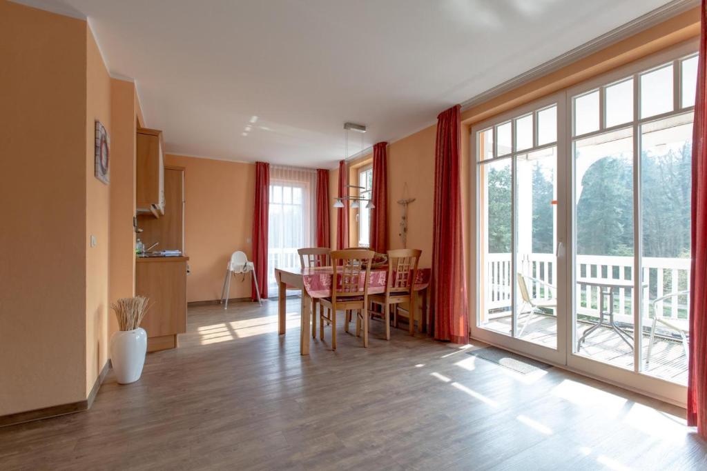 a kitchen and dining room with a table and a large window at Villa-Senta-Apartment-8 in Kühlungsborn