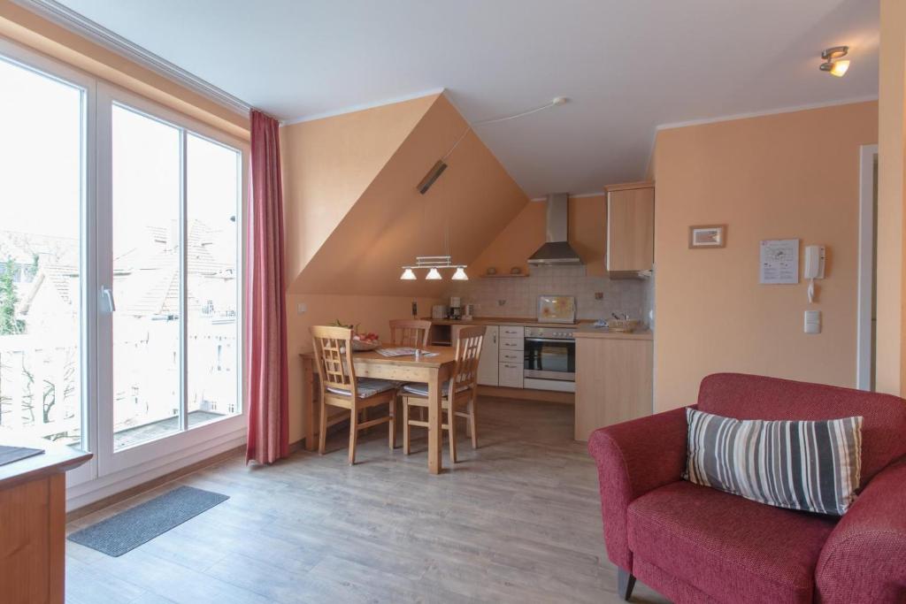 Villa-Senta-Apartment-13 في كولونغسبورن: مطبخ وغرفة معيشة مع طاولة وأريكة