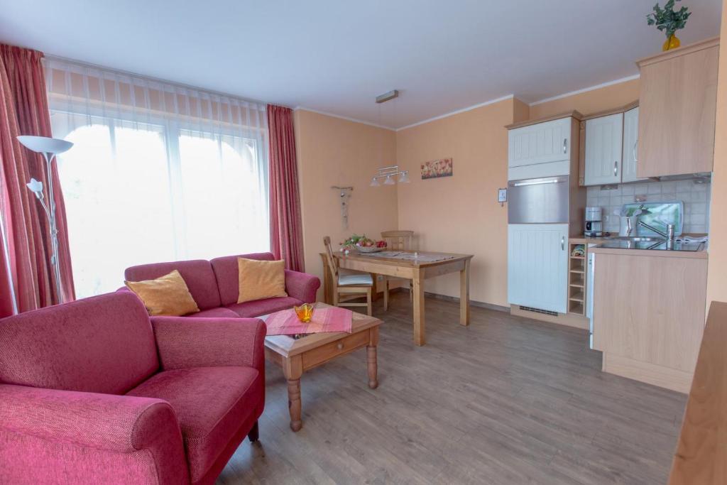 a living room with a couch and a table and a kitchen at Villa-Senta-Apartment-14 in Kühlungsborn