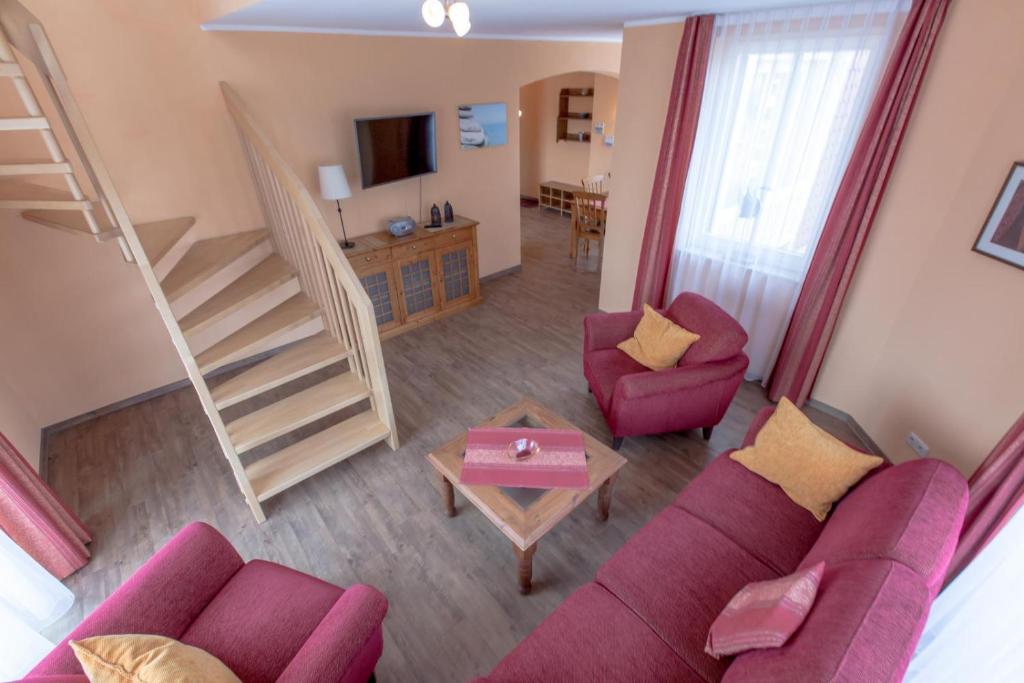 a living room with a couch and two chairs and a staircase at Villa-Senta-Apartment-15 in Kühlungsborn