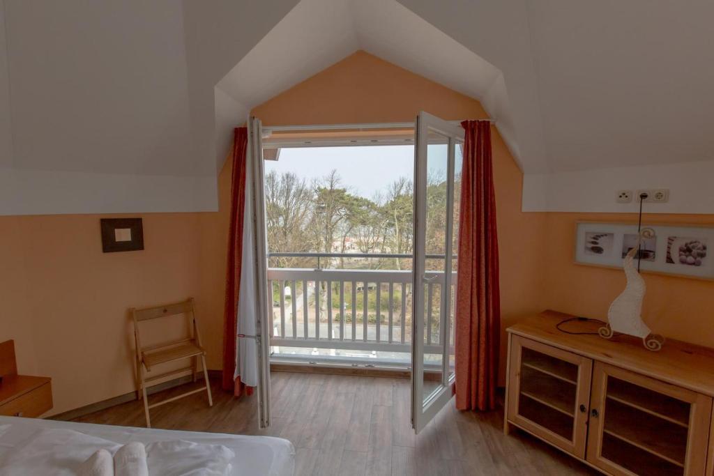 une chambre avec une porte ouverte sur un balcon dans l'établissement Villa-Senta-Apartment-15, à Kühlungsborn