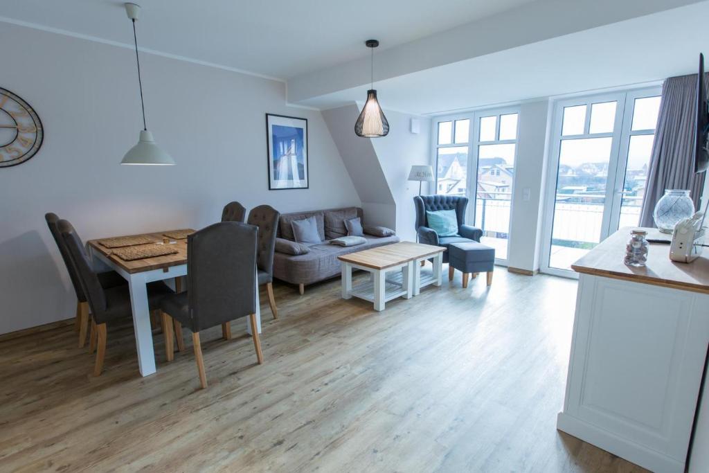 a kitchen and living room with a table and a couch at Sunnevelt-Apartment-18 in Kühlungsborn