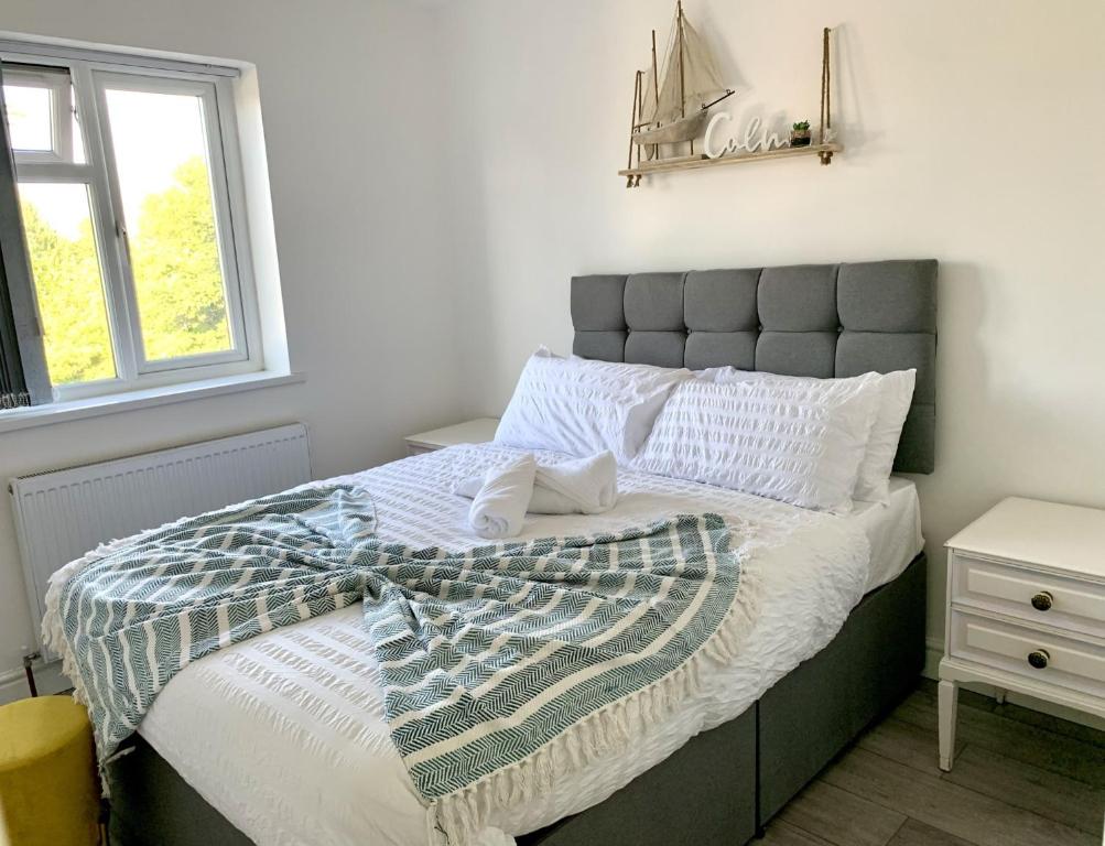 a bedroom with a large bed with a gray headboard at Modern & Cosy 2-Bed Apartment Near NEC, Airport & JLR! in Birmingham
