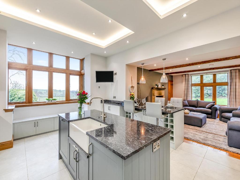 an open kitchen and living room with a view of a living room at Buntingfield Farmhouse in Ashover