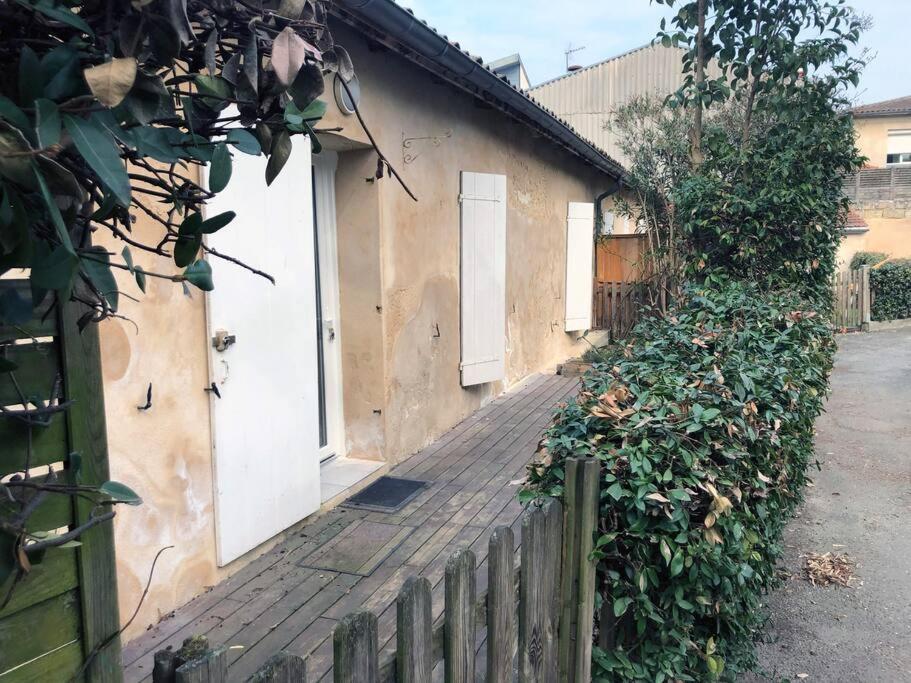 a building with white doors and a wooden fence at Echoppe Bordelaise chaleureuse in Bordeaux
