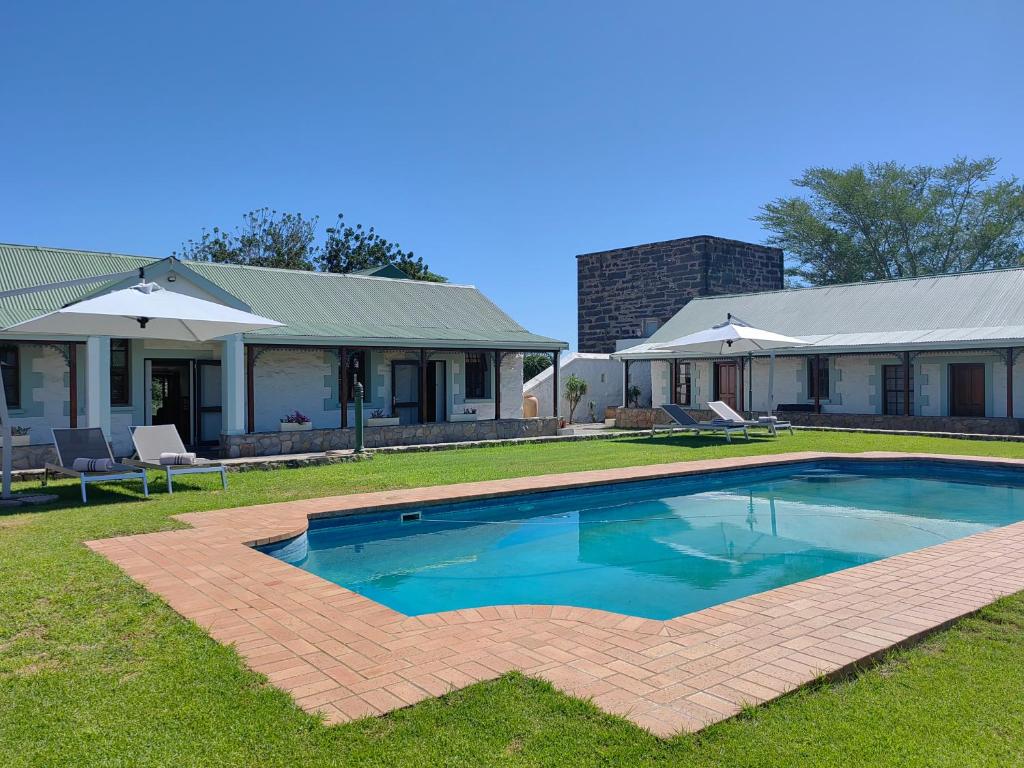 a large swimming pool in front of a house at Trumpetters Drift Game Farm in Grahamstown