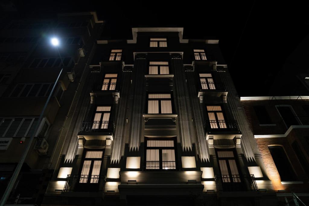 a tall building with lit up windows at night at Monev Suites Hotel in Istanbul