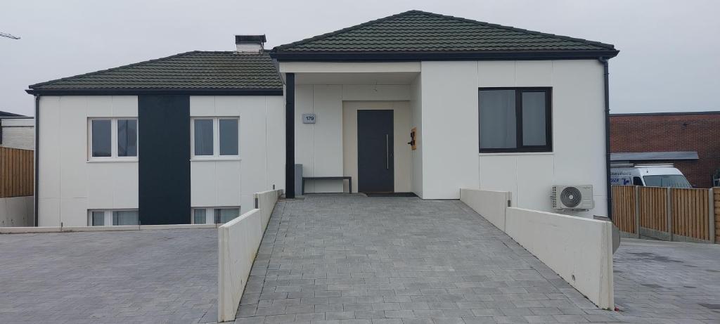 une maison blanche avec une passerelle devant elle dans l'établissement Louis, à Maaseik