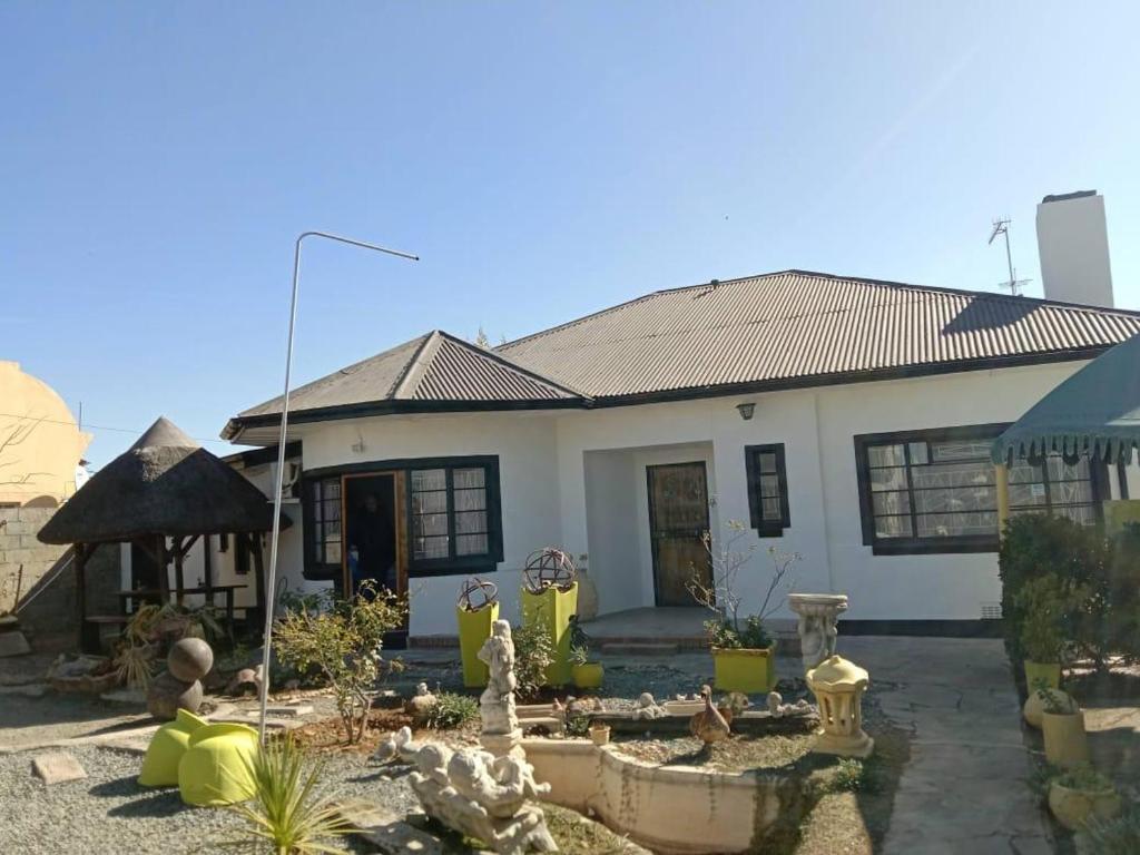 a white house with a garden in front of it at Garden Cottage Guest House in De Aar