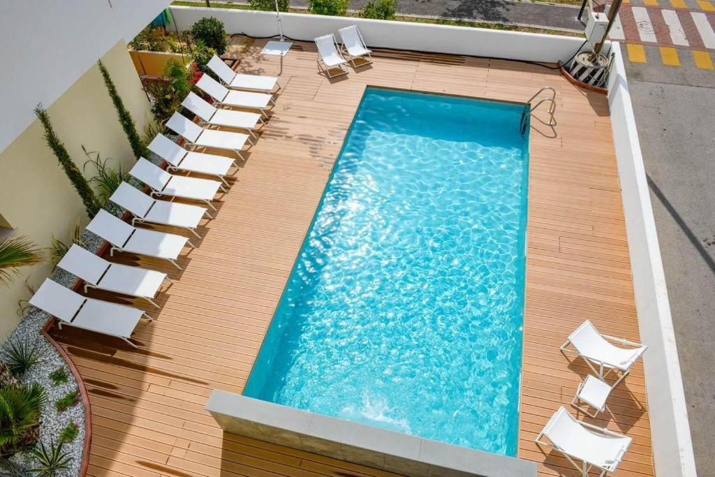 an overhead view of a swimming pool with lounge chairs and a swimming pool at Sun Light in Lido di Jesolo