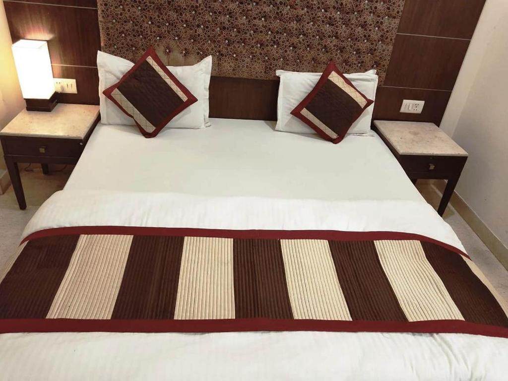 a large bed in a hotel room with two tables at City Plaza in Panchkula
