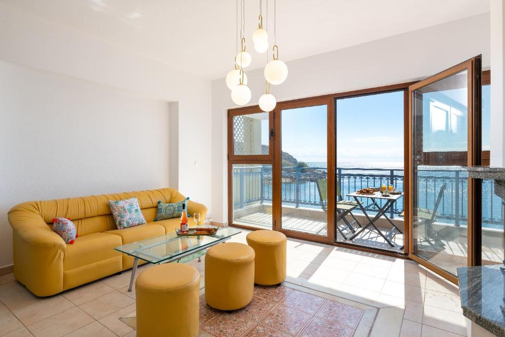 a living room with a yellow couch and a glass table at Artoria Apartment 2 First Floor in Haraki