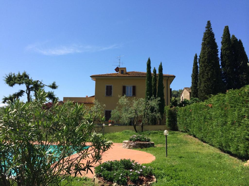 een huis met een tuin en een zwembad bij Podere San Giusto in Figline Valdarno