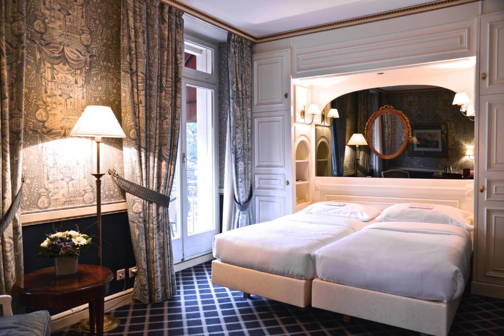 - une chambre avec un grand lit et une fenêtre dans l'établissement Carlton Lausanne Boutique Hôtel, à Lausanne