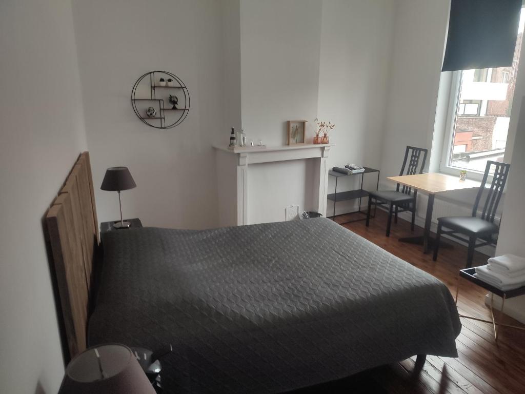 sypialnia z łóżkiem, stołem i krzesłem w obiekcie Het Kapittel w mieście Ypres