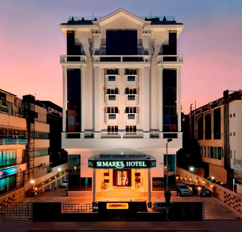 バンガロールにあるセント マークス ホテルの目の前に看板が立つ白い大きな建物
