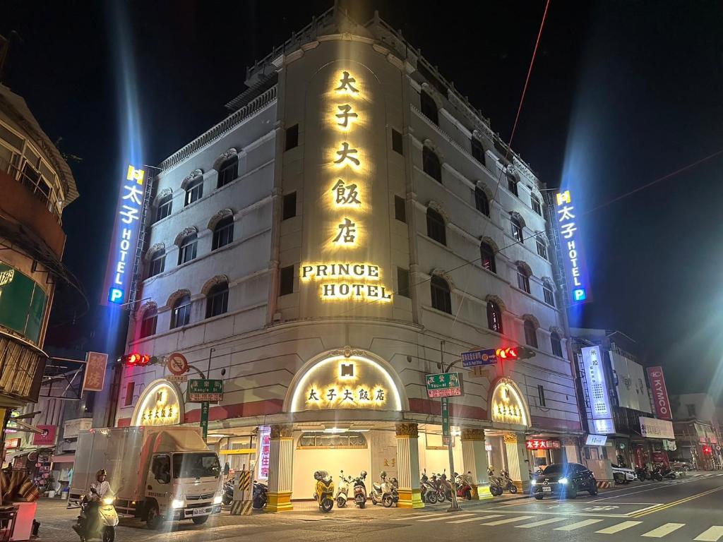 台南的住宿－太子大飯店，一座建筑,上面有标志,晚上读王子酒店