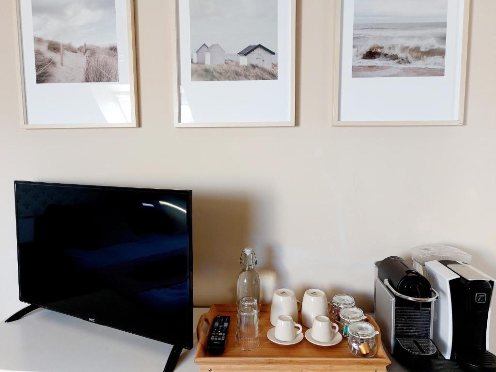 a flat screen tv sitting on a table with a coffee maker at Chambres d&#39;hôtes chez l&#39;habitant - Bed&amp; Breakfast homestay in Huisnes-sur-Mer