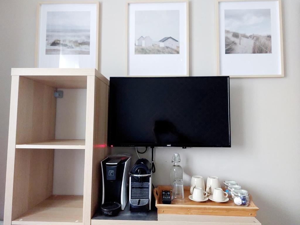 a flat screen tv hanging on a wall at Chambres d&#39;hôtes chez l&#39;habitant - Bed&amp; Breakfast homestay in Huisnes-sur-Mer