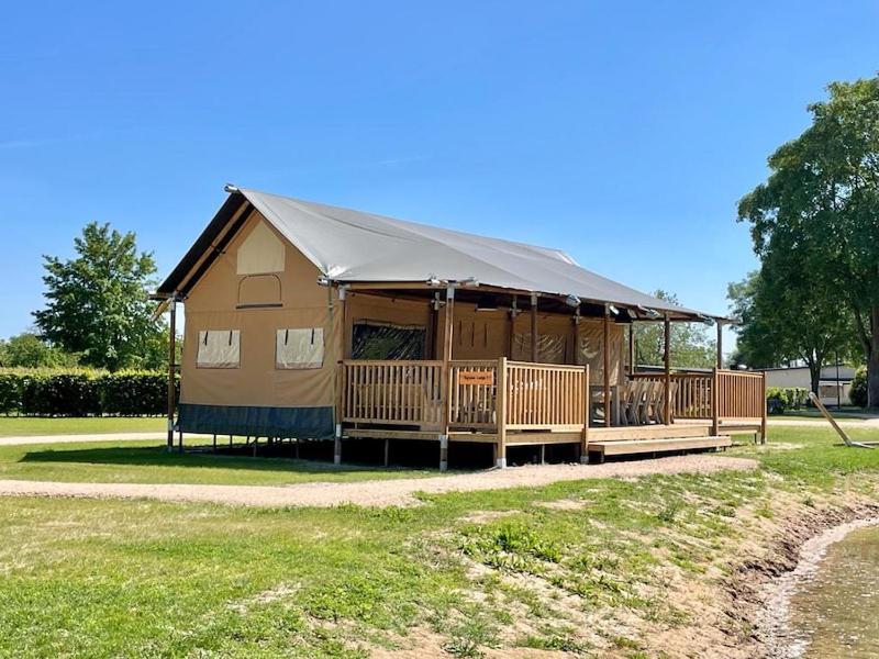 un gran edificio con una tienda en un campo en Safaritent Betuwe Lodge, en Kesteren