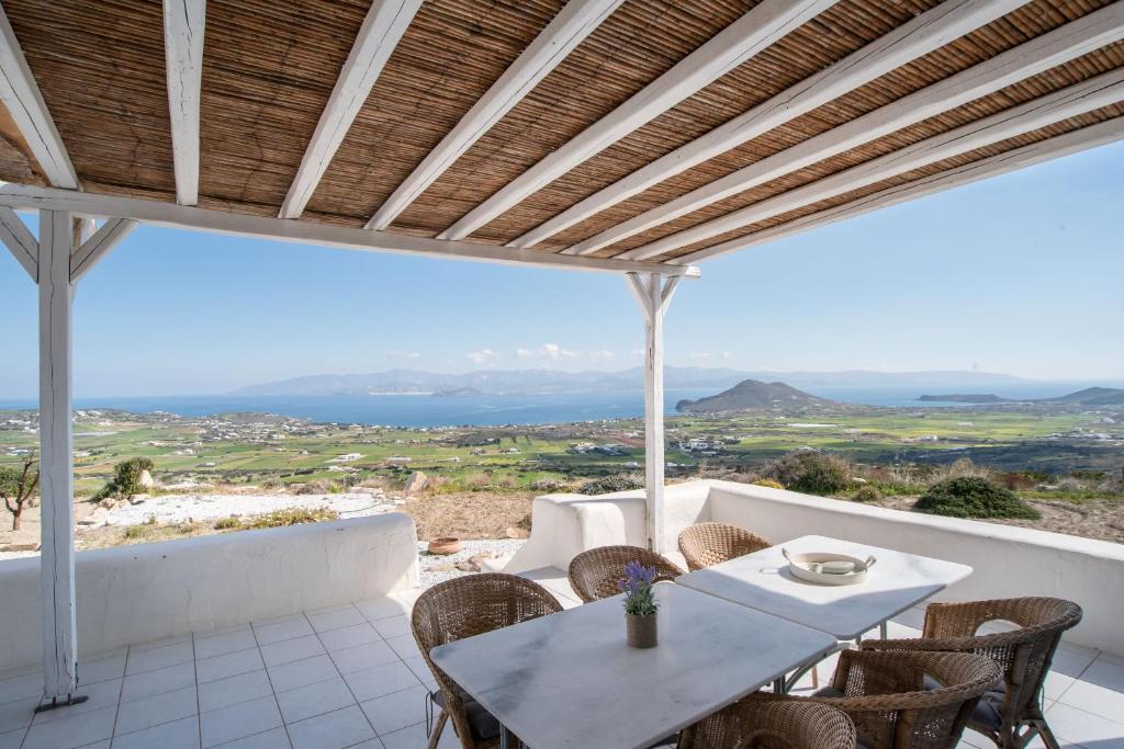 un patio avec une table et des chaises et une vue dans l'établissement Overlooking Sea Maisonette With BBQ For 7 Ppl, à Kóstos